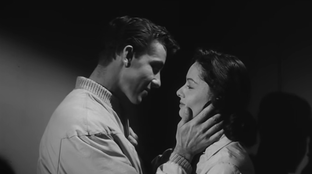 A man and a woman are gazing into each other's eyes in a close embrace, conveying a sense of intimacy and connection.
