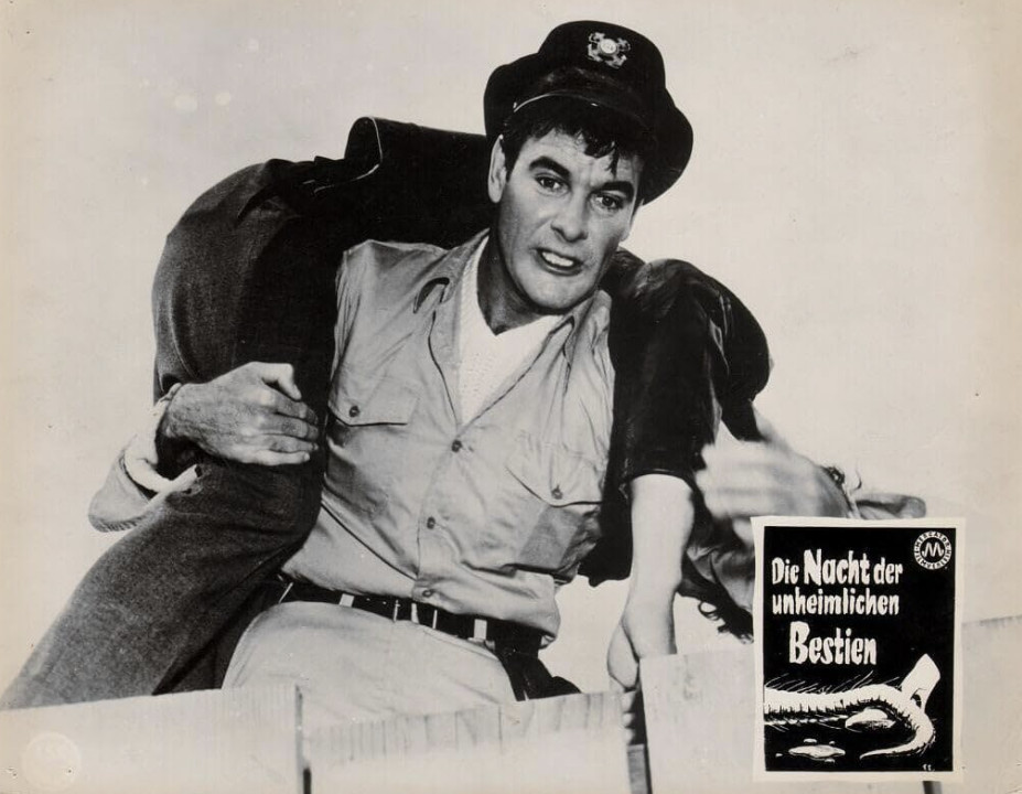 A man in a police uniform is carrying another person over his shoulder. The scene depicts urgency, with a focus on their expressions. An advertisement for a film titled 'Die Nacht der unheimlichen Bestien' is visible in the corner.